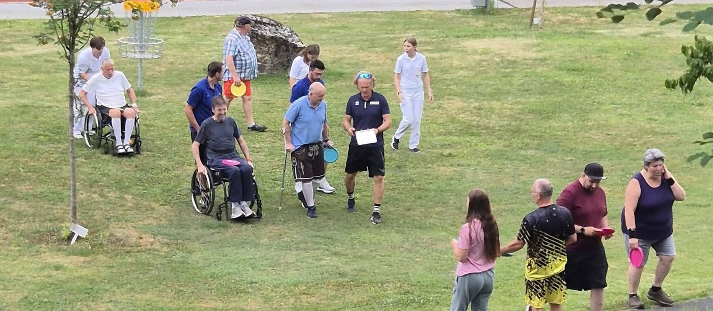 Účastníci inkluzivní discgolfové akce na hřišti